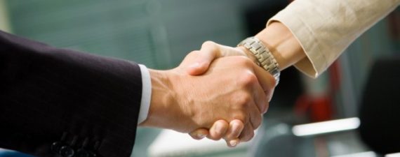 People at work: man and woman hand shaking at a meeting