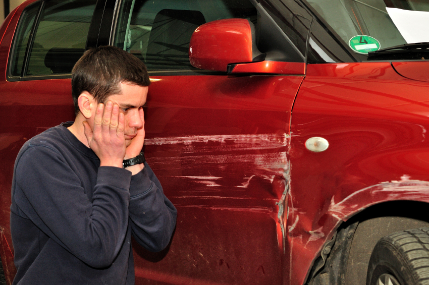 Car driver with his damaged car.