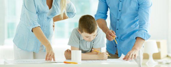Pregnant mother, father and son drawing a plan of their new house