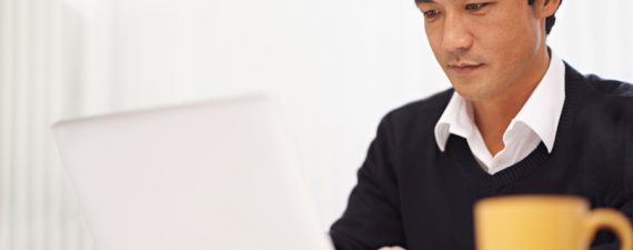 Shot of a handsome asian businessman working on his laptop in the office