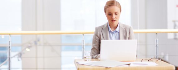 Female CEO typing on computer in empty office