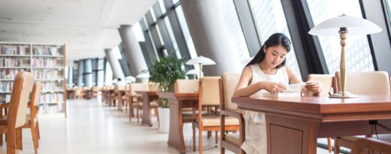 beautiful chinese female students in the university campus library reading