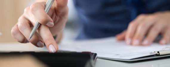 Close up of female accountant or banker making calculations. Savings, finances and economy concept