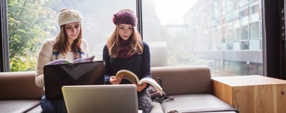 Two college students study in the library.