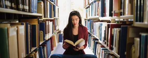 Young asian woman reading in library