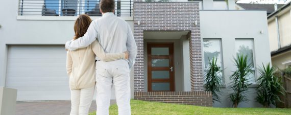 Mature couple looking at a house. Rear view