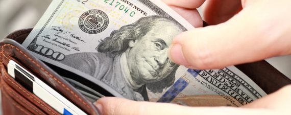Person Taking Money Out of Wallet
