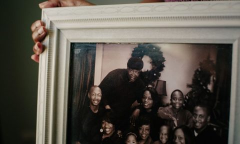 Taunya Kennedy holds a family portrait in her home in a suburb south of Chicago. Credit: Alyssa Schukar